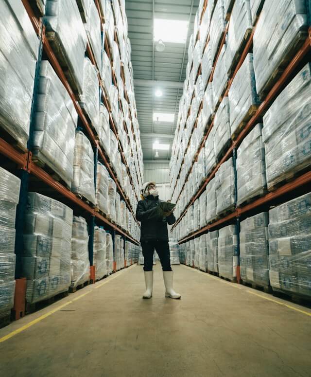 A warehouse manager examines inventory