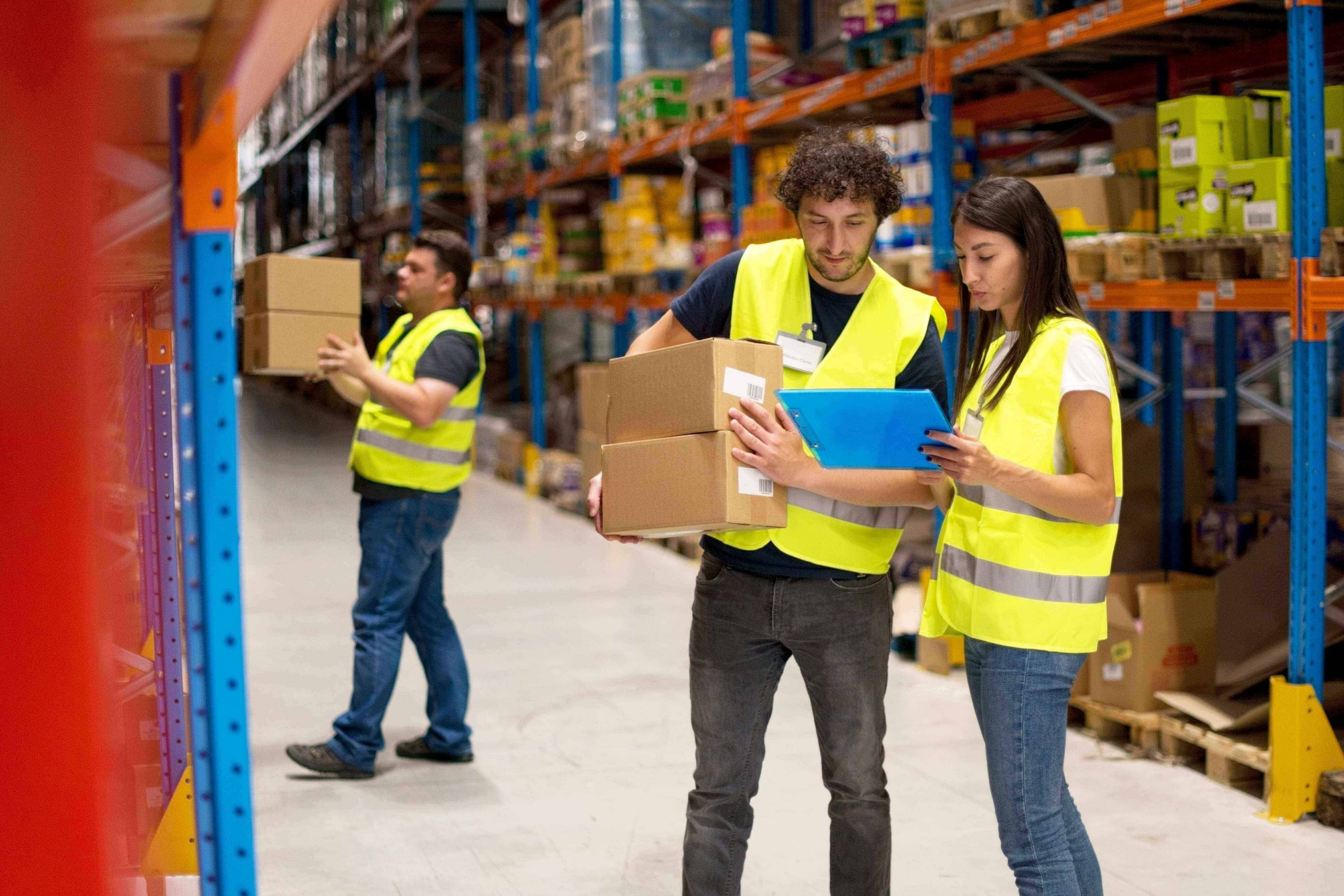 Three warehouse workers collaborate using a 3PL inventory management system to move their stock.