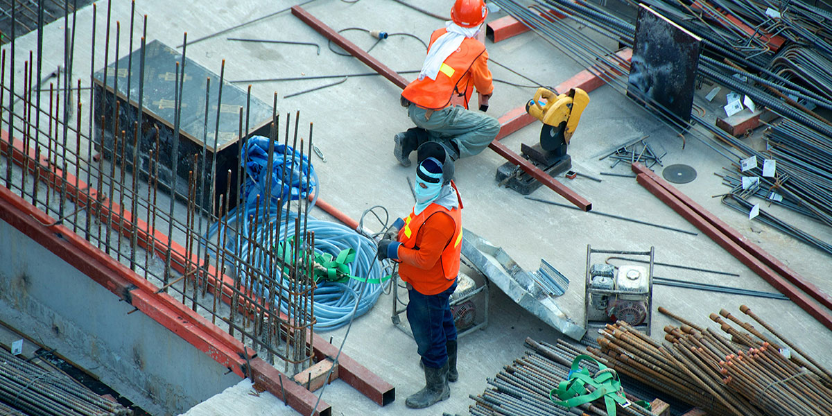 two men working on a construction site surrounded by materials